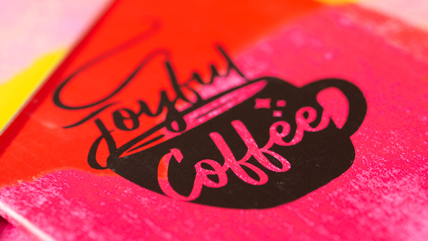 Closeup detail of packaging showing bold Joyful Coffee illustration